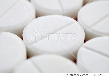 Close-up image of white pills. Macro with extremely shallow depth of field Close-up image of white pills. Macro with extremely shallow depth of field 94612596