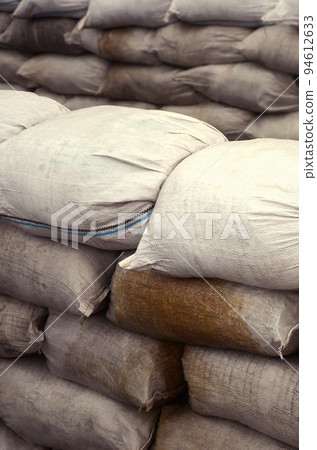 Background of many dirty sand bags for flood defense. Protective sandbag barricade for military use. Handsome tactical bunker 94612633
