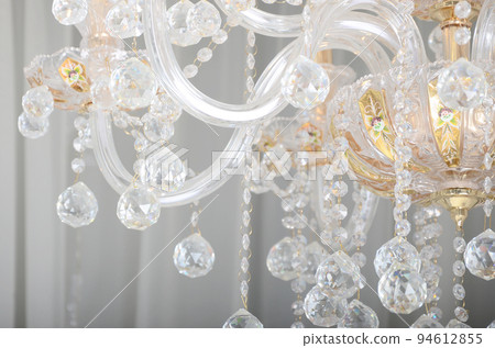 Close-up photo of the scenery on the old chandelier. Glass figures shine and reflect light with their faces 94612855