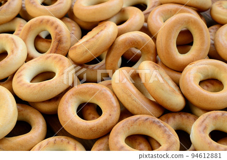 Close-up photo of fresh yellow bagels. A popular kind of flour products. One of the traditional Russian treats for tea Close-up photo of fresh yellow bagels. A popular kind of flour products. One of the traditional Russian treats for tea 94612881