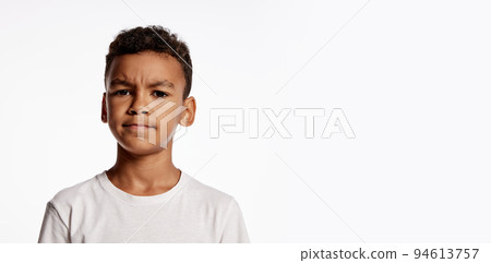 Doubts. Half-length portrait of african little boy in white tee expressing emotions isolated over white background. Kids emotions concept 94613757
