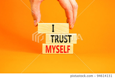 I trust myself symbol. Concept words I trust myself on wooden blocks. Businessman hand. Beautiful orange table orange background. Business, psychological and I trust myself concept. Copy space. 94614131