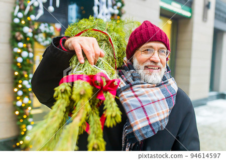happy retired man walking by street with christmas tree to home from market happy retired man walking by street with christmas tree to home from market 94614597