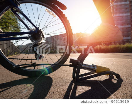 Man inflating bike tire outdoors. Pumping up bicycle tyre 94615619