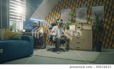 Man at home wearing VR headset Man at home wearing VR headset 94616625