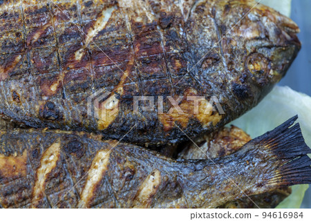 whole, grilled Dorado fish on a charcoal grill 94616984