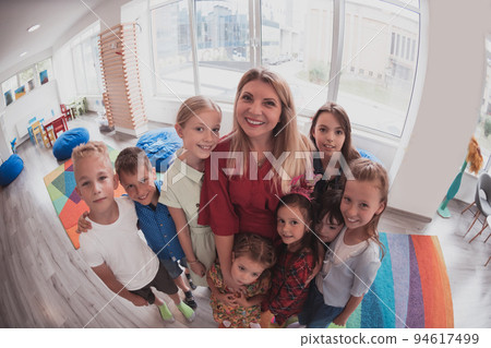 photo of children in a preschool institution standing in the classroom together with the teacher 94617499