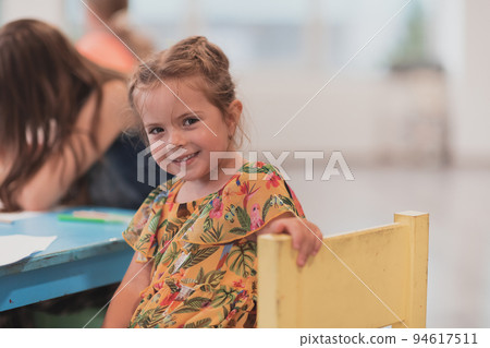 Creative kids sitting in a preschool institution, draw and have fun while they get an education Creative kids sitting in a preschool institution, draw and have fun while they get an education 94617511