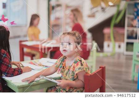 Creative kids sitting in a preschool institution, draw and have fun while they get an education Creative kids sitting in a preschool institution, draw and have fun while they get an education 94617512