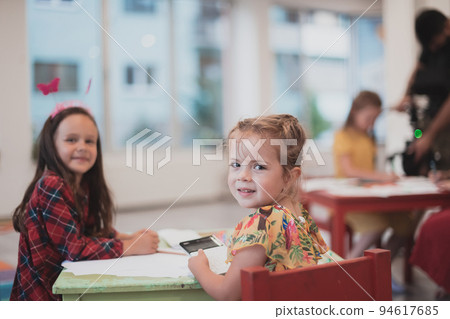Creative kids sitting in a preschool institution, draw and have fun while they get an education Creative kids sitting in a preschool institution, draw and have fun while they get an education 94617685