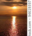 夕陽在傍晚漂浮在海面上，與雲層重疊 94619397