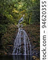 Waterfall surrounded by autumn leaves 94620355