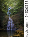 Waterfall surrounded by autumn leaves 94620358