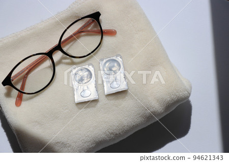 Glasses and contact lenses on the face towel (white background) Glasses and contact lenses on the face towel (white background) 94621343