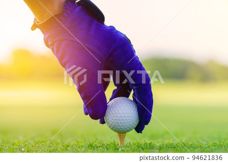 Hand Golfer hold Golf ball with tee ready to be shot at golf court Hand Golfer hold Golf ball with tee ready to be shot at golf court 94621836