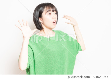 A young woman doing a surprised pose in front of a white background A young woman doing a surprised pose in front of a white background 94621943