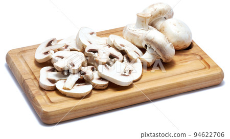 Sliced white champignon mushrooms on wooden cutting board isolated on white background 94622706