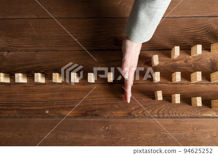 Businesswoman protecting dominoes from falling Businesswoman protecting dominoes from falling 94625252