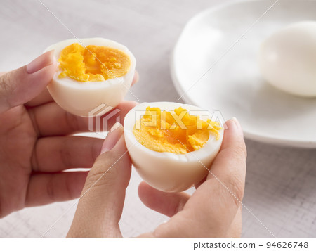 Woman's hand holding a boiled egg Woman's hand holding a boiled egg 94626748