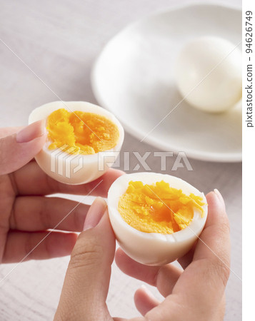 Woman's hand holding a boiled egg Woman's hand holding a boiled egg 94626749