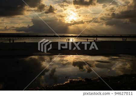 Clouds and an airplane reflected on the water surface Clouds and an airplane reflected on the water surface 94627011