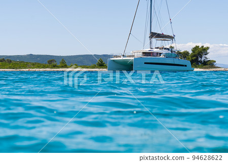 catamaran sailing in ocean. paradice at sea. Blue sky and turquoise blue sea water. catamaran sailing in ocean. paradice at sea. Blue sky and turquoise blue sea water. 94628622