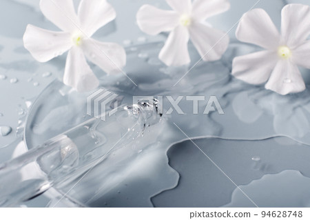 Pipette, cosmetic product and White flowers in petri dish on grey background, selective focus 94628748