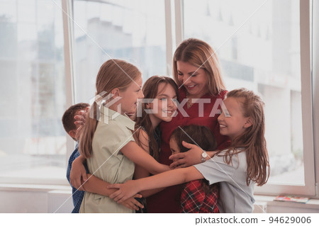 A child hugging a teacher in a modern kindergarten A child hugging a teacher in a modern kindergarten 94629006
