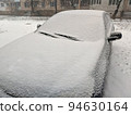 Closeup image of frosen car wipes lying on windshield 94630164