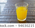 Orange juice drink, a close up of glass of tasty tropical juice beverage on wood table. 94630215