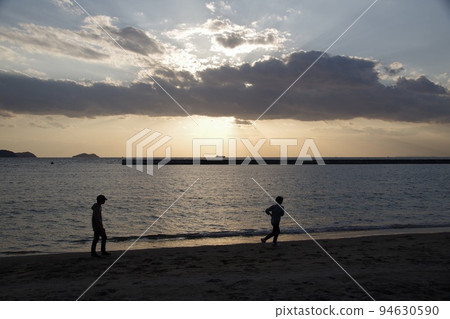 Two people on the beach at dusk Two people on the beach at dusk 94630590