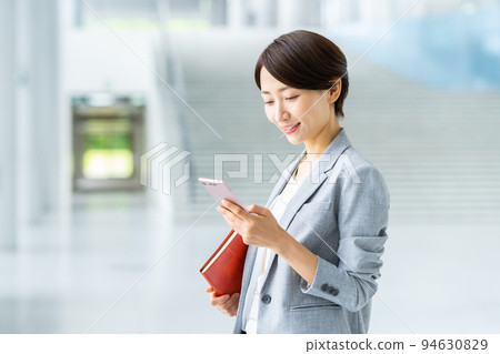Middle career woman looking at a smartphone Middle career woman looking at a smartphone 94630829