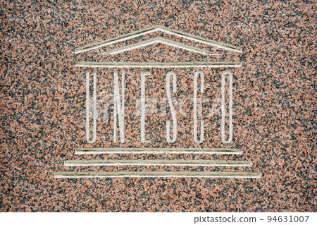Russia, Krasnodar - September 12 2022: Close up of UNESCO world heritage sign carved on stone in Velikiy Novgorod Russia, Krasnodar - September 12 2022: Close up of UNESCO world heritage sign carved on stone in Velikiy Novgorod 94631007