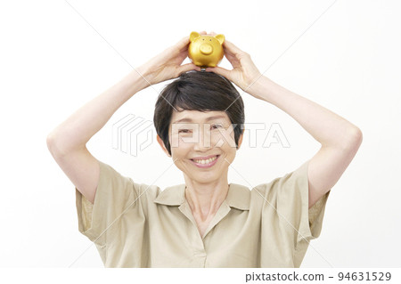 拿著存錢罐白色背景的一位微笑的中年婦女 94631529