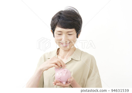 中年婦女在豬存錢罐裡存錢 白色背景 94631539