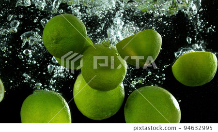Lime fruit falling down and splashing underwater. 94632995