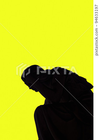 Statue shadow silhouette of an angel against a yellow background. Statue shadow silhouette of an angel against a yellow background. 94633197