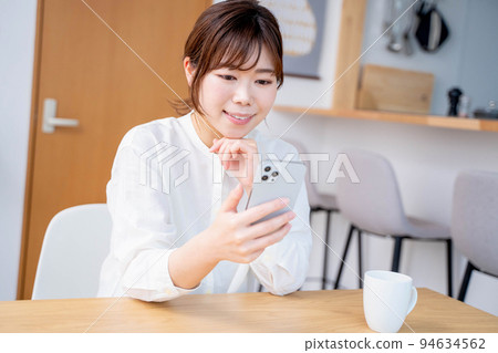 Young woman living room lifestyle smartphone Young woman living room lifestyle smartphone 94634562