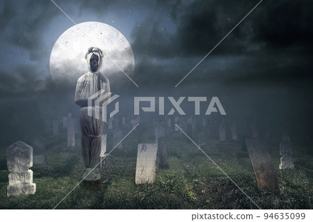 Pocong is covered with a white linen shroud standing 94635099