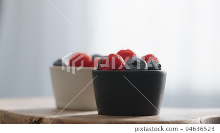 Fresh berries in bowl on linen napkin 94636523