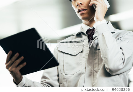 Young man in work clothes making a phone call in the office 94638296