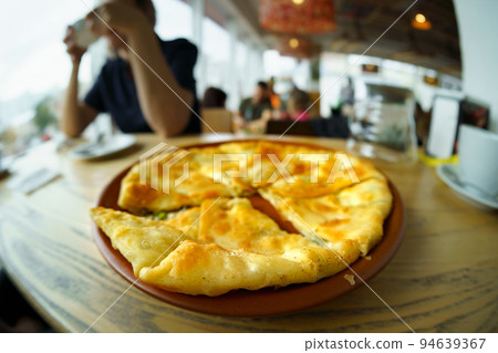 One placinda on a wooden table. Flour products of Moldovan cuisine include various fried pies with stuffing, cottage cheese or potatoes, cabbage, etc. One placinda on a wooden table. Flour products of Moldovan cuisine include various fried pies with stuffing, cottage cheese or potatoes, cabbage, etc. 94639367