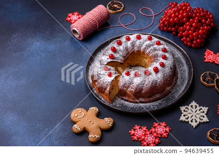 Homemade delicious round Christmas pie with red berries on a ceramic plate 94639455