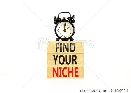 Find your niche symbol. Concept words Find your niche on wooden blocks. Black alarm clock. Beautiful white table white background. Business and find your niche concept. Copy space. 94639634