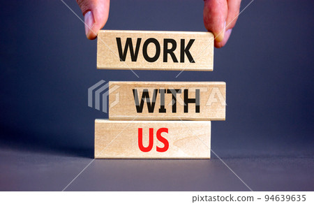 Work with us symbol. Concept words Work with us on wooden blocks on a beautiful grey table grey background. Businessman hand. Business, motivational and work with us concept. Copy space. 94639635