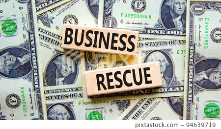 Business rescue symbol. Concept words Business rescue on wooden blocks on a beautiful background from dollar bills. Business rescue and support concept. Copy space. 94639719