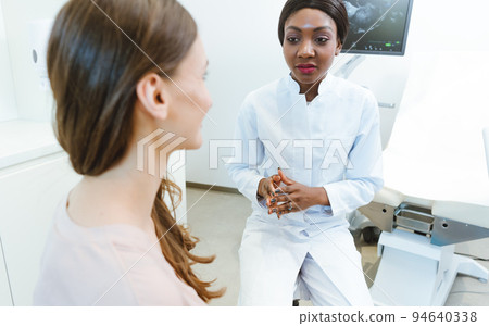 Gynecologist showing woman early ultrasounds of her pregnancy 94640338