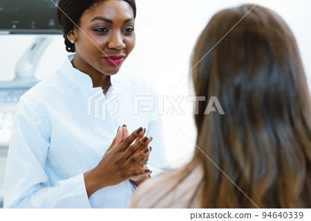 Gynecologist showing woman early ultrasounds of her pregnancy Gynecologist showing woman early ultrasounds of her pregnancy 94640339