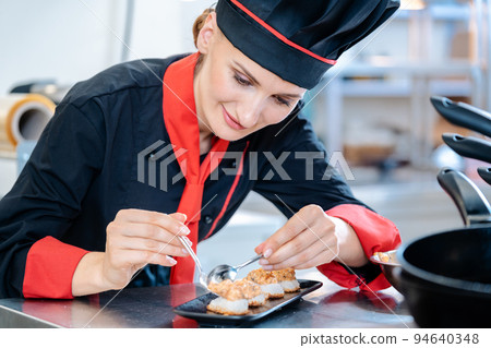 Chef seasoning an appetizer in kitchen Chef seasoning an appetizer in kitchen 94640348