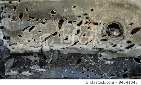 Damaged and destroyed civilian car with shrapnel holes from Russian missile in a war zone in Kharkiv, Ukraine 94641045